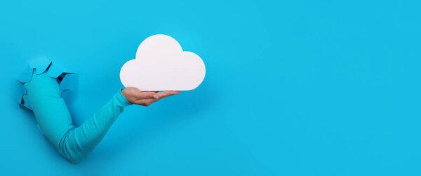 hand holding cloud over blue background, cloud storage, cloud computing concept, panoramic layout